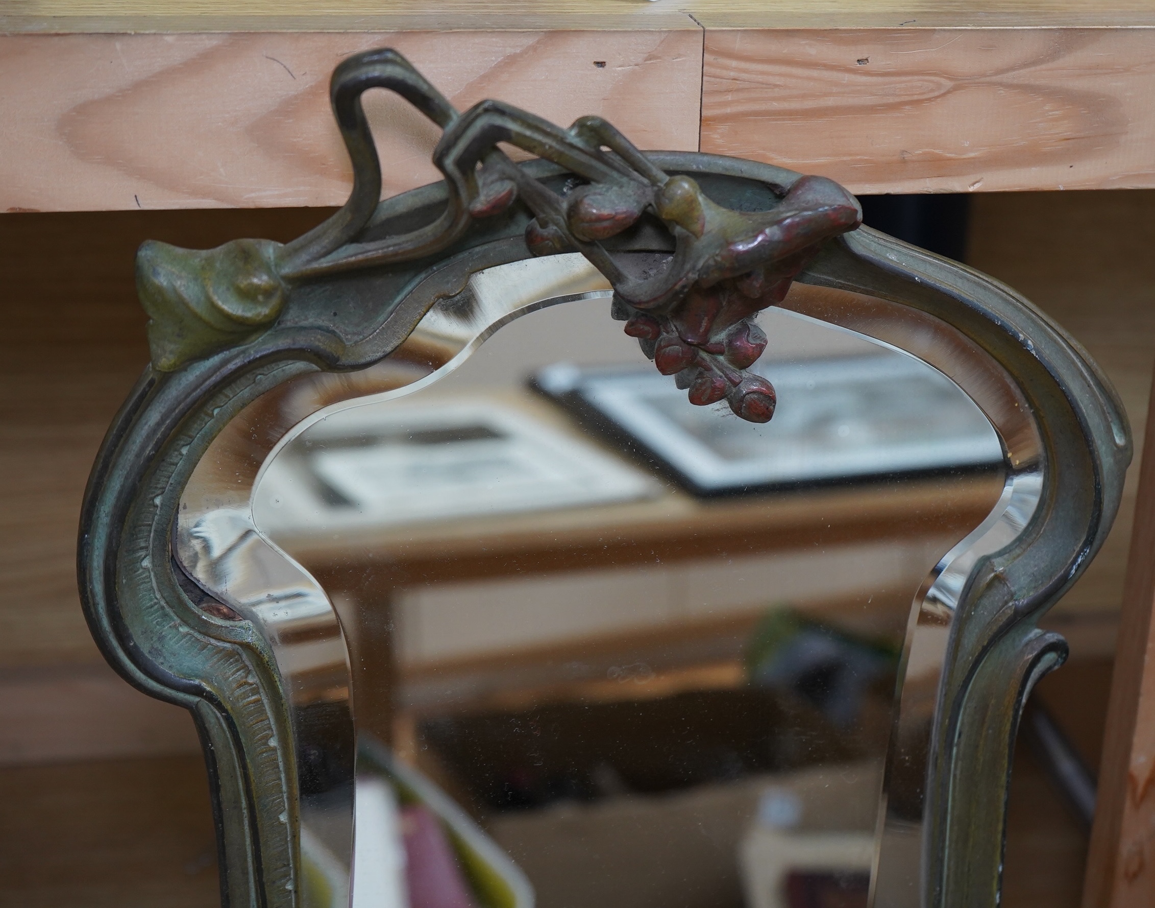 An Art Nouveau painted spelter mirror, signed and stamped on reverse, 44cm high. Condition - front has some wear, back has easel stand missing